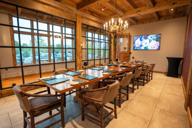 Photo of long wood table surrounded by 12 seats and set for a dinner party in the Chef's Table at Annie Gunns